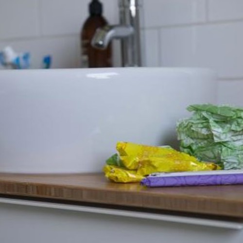 A selection of period products place on the side of a sink in a bathroom. 